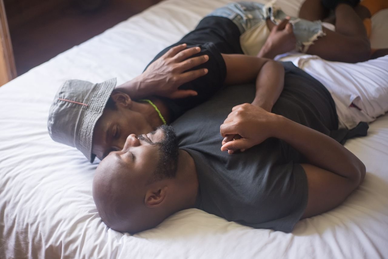 Intimate moment of a couple lying together in a comfortable indoor setting.